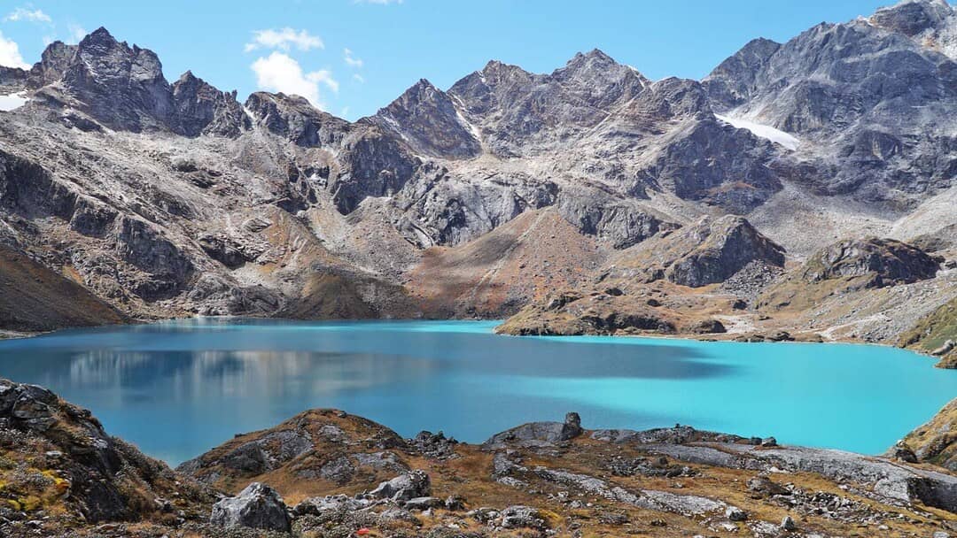 A turquoise highland lake surrounded by jagged mountains in eastern Bhutan