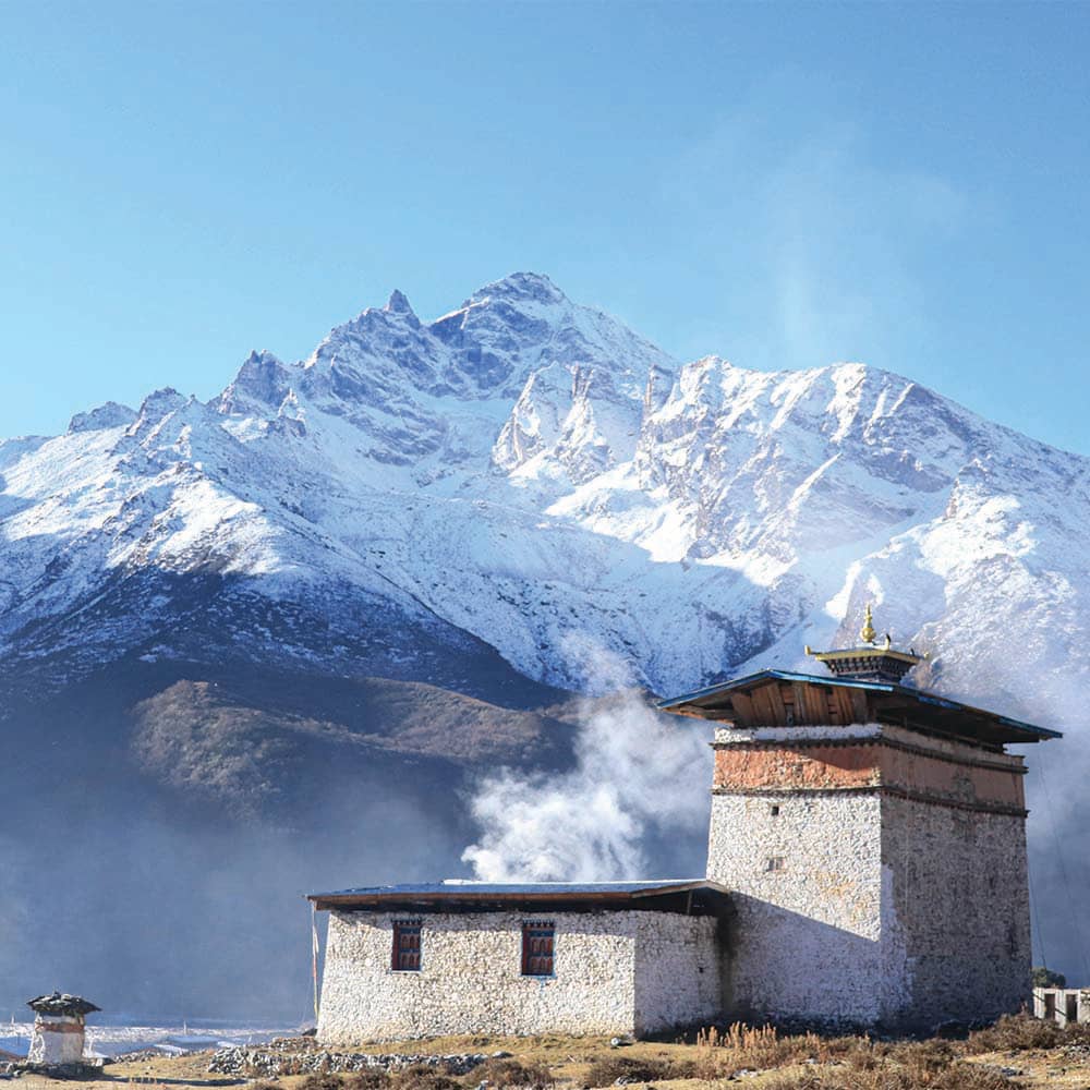 A high-altitude temple beneath a snow-covered mountain in Lunana