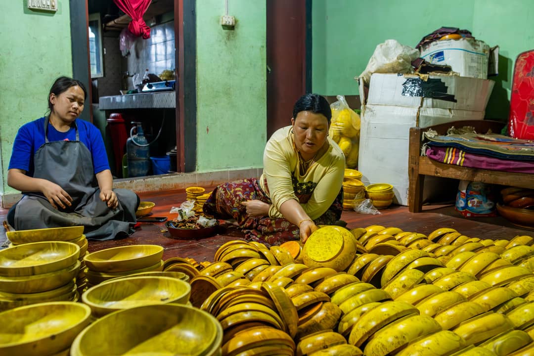 Artisans shaping traditional wooden bowls in Trashiyangtse