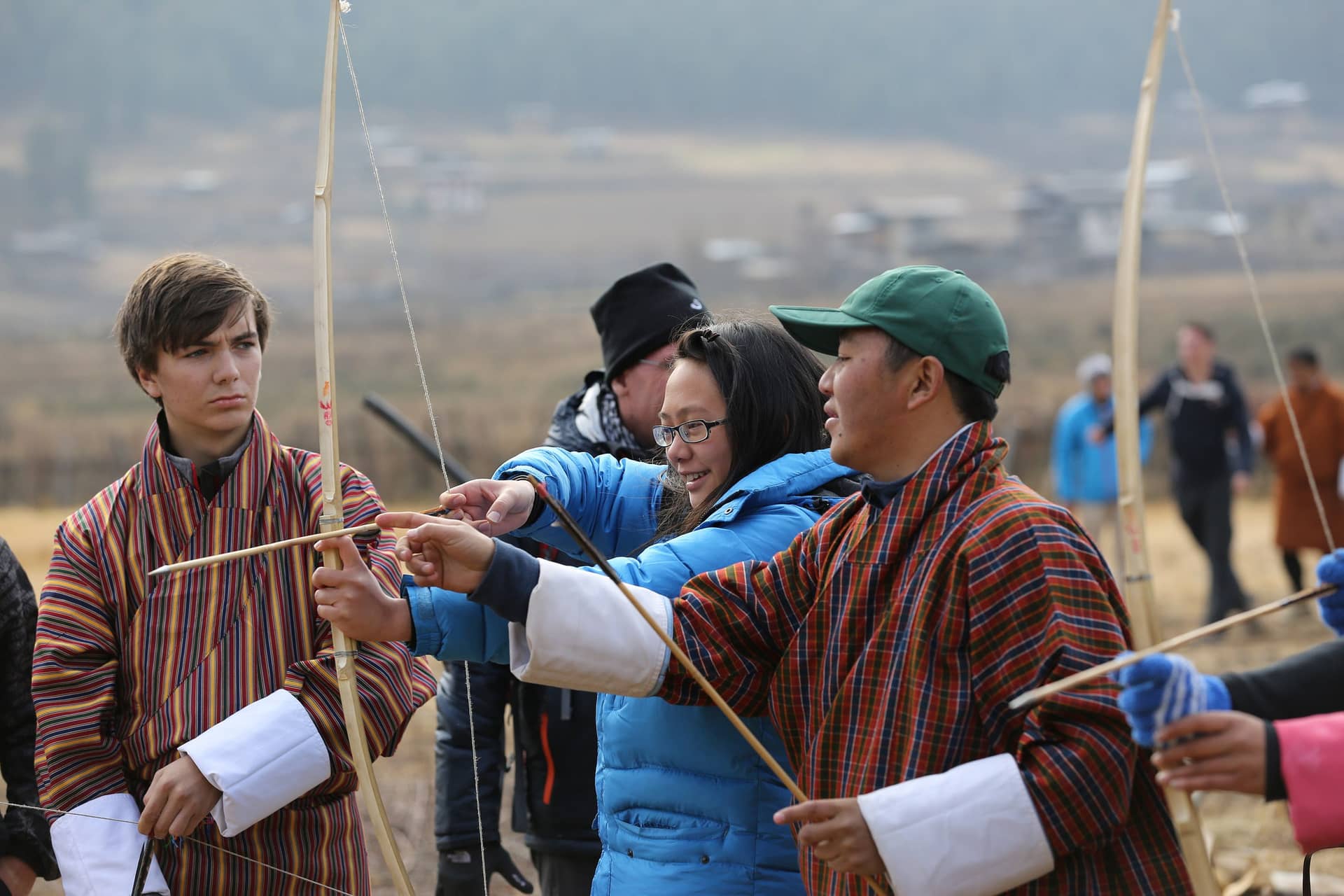 A traveler learning archery with a local Bhutanese instructor