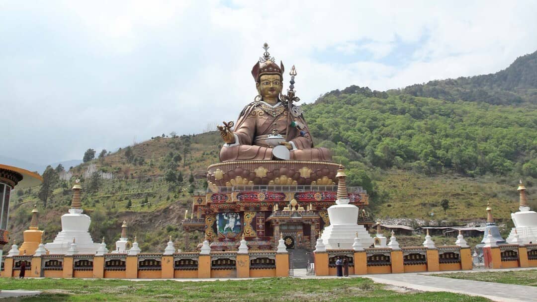 A large Guru Rinpoche statue and white chortens at Takila in Lhuentse