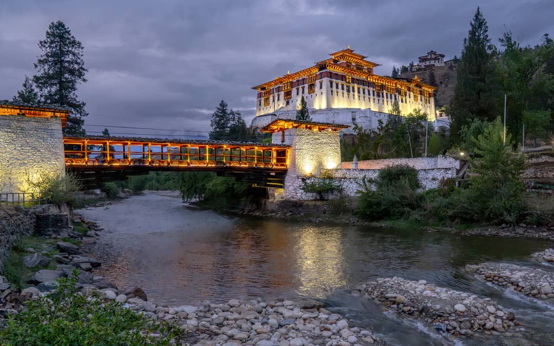Paro Dzong illuminated above the river in the evening